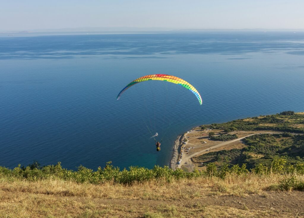 a paraglider is flying over a body of water